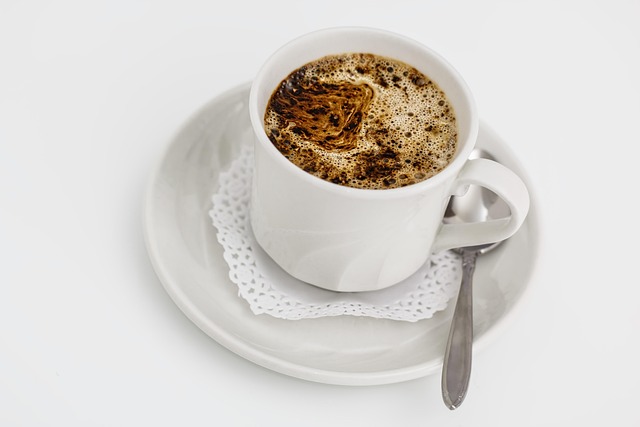 Une tasse blanche de café chaud sur une soucoupe, idéale pour un Mug Humoristique.