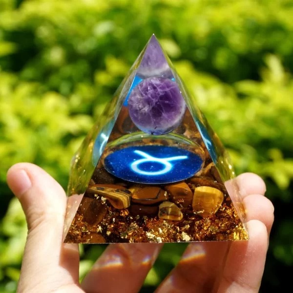 Une pyramide orgonite de couleur violette, avec des couches transparentes et des inclusions métalliques et cristallines